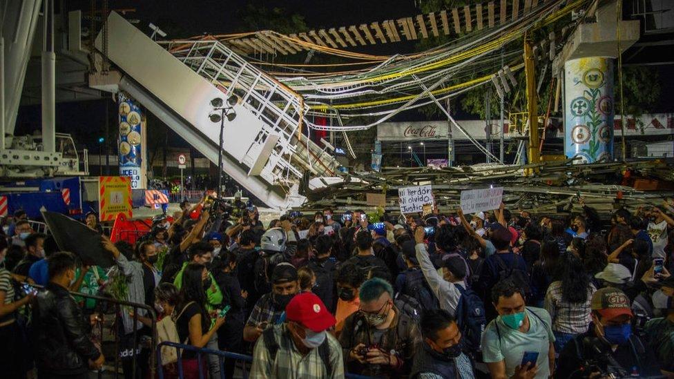 People gather to protest at the site of a train accident