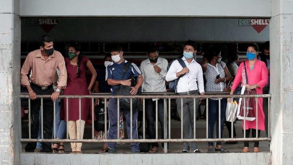 Passengers wait for a bus in Colombo, Sri Lanka