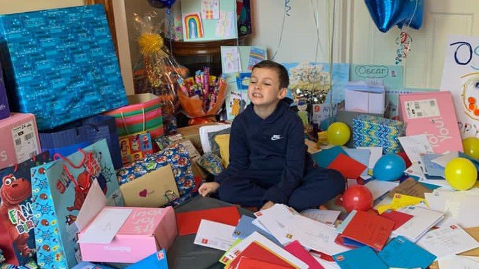 Oscar sits with some of the cards, presents, drawings and balloons he received