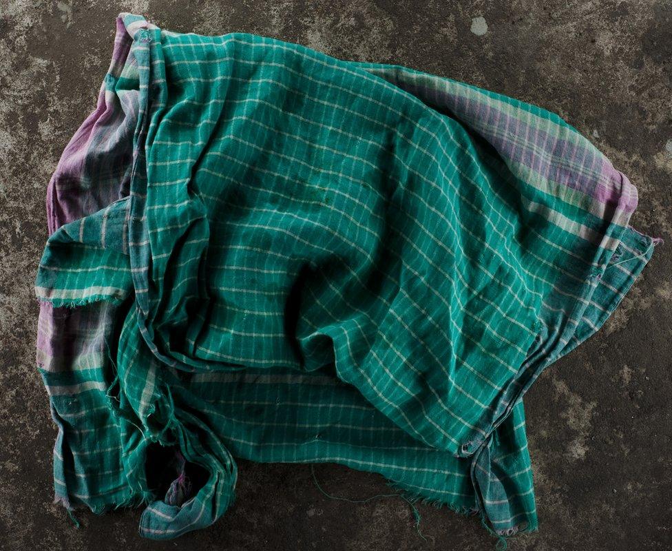 A piece of fabric lying on concrete. Gamcha. Part of 'Crossfire', a photo story by Shahidul Alam. February 13, 2010.