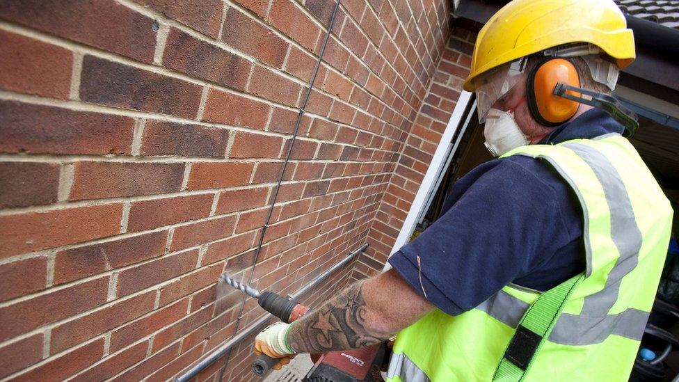 A man installing cavity wall insulation