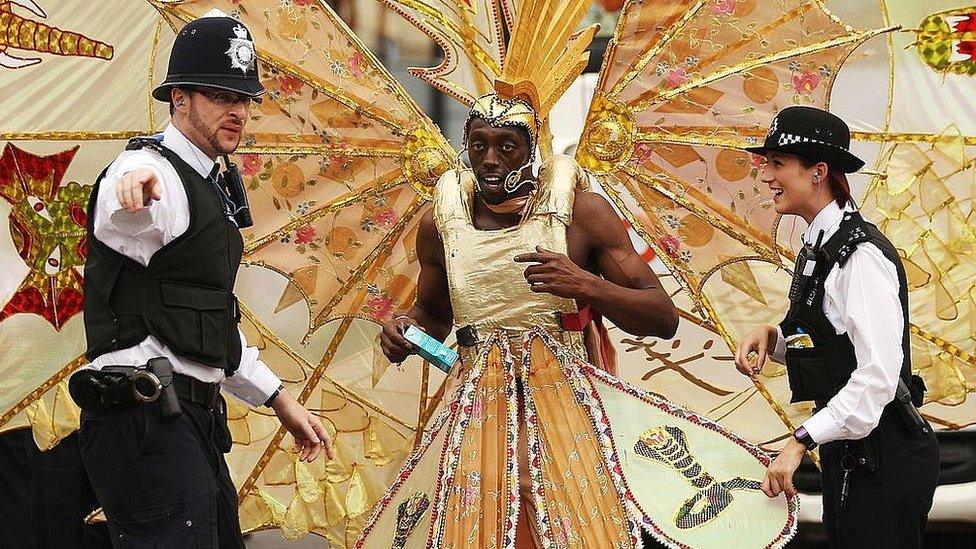 Police officers direct a carnival-goer at the Notting Hill Carnival 2012