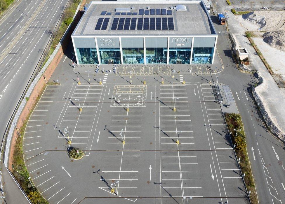 An aerial view of a large Next store next to an empty car park