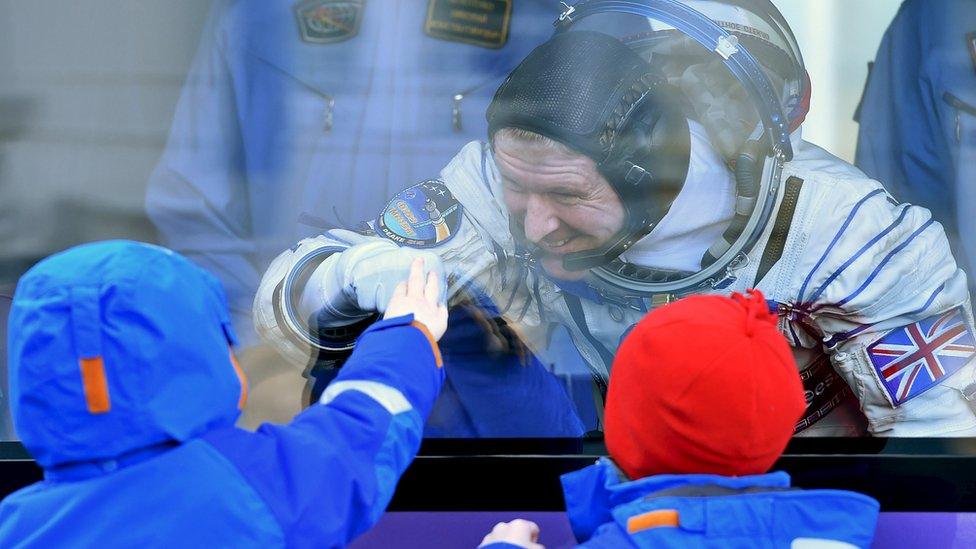 Tim Peake waving to his children through glass