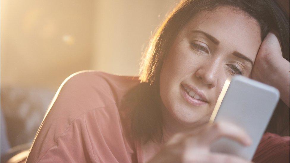 Young woman using a dating app on her phone