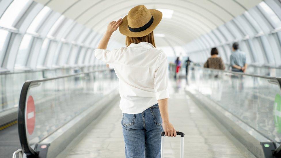 Female traveller with suitcase at airport