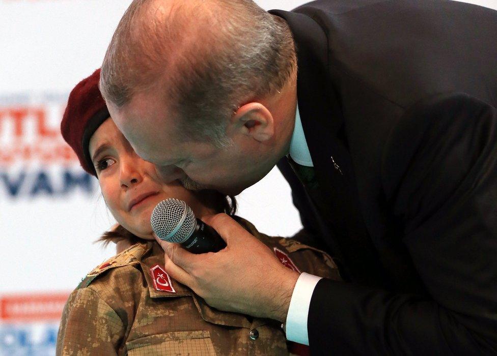 Turkish President Recep Tayyip Erdogan kisses a girl dressed as a Turkish soldier during the 6th ordinary provincial congress of the Justice and Development Party (AKP)