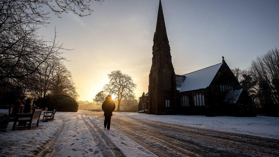 A person walks through Allerton Cemetery near Liverpool on Thursday