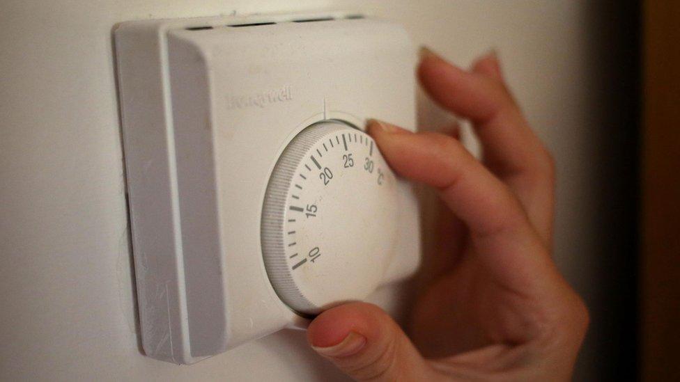 Person using a central heating thermostat