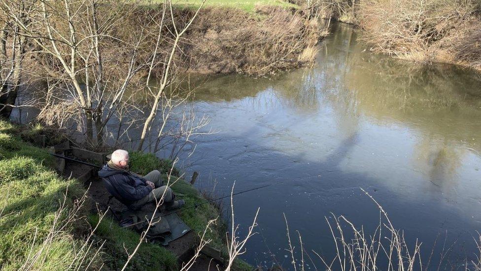 A man fishing in the River Medway