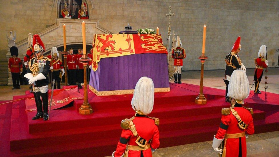 The coffin of Queen Elizabeth II, draped in the Royal Standard with the Imperial State Crown placed on top, lays on the catafalque in Westminster Hall