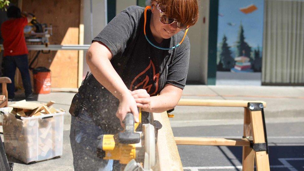 woman sawing wood