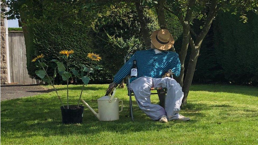 Scarecrow asleep under tree