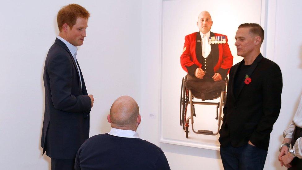 Prince Harry talks to Rick Clement, photographer and singer Bryan Adams