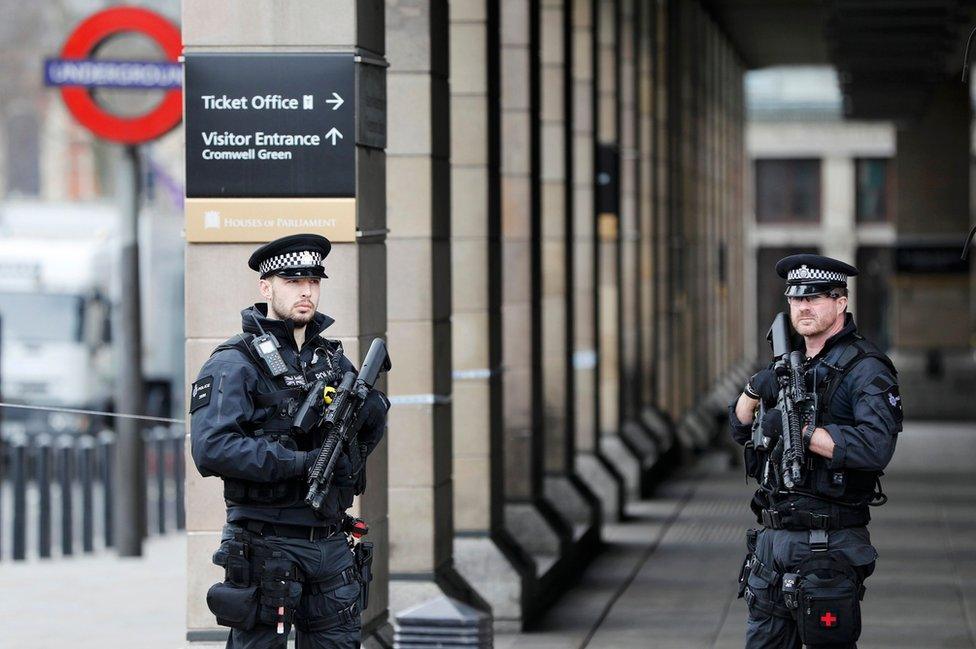 Armed police officers patrol outside Westminster underground station