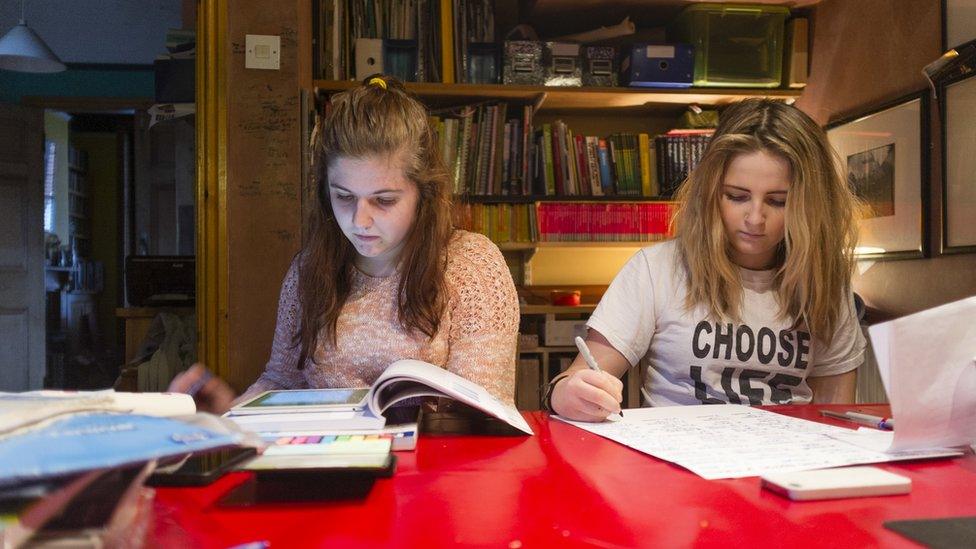 2 girls sitting at a desk doing homework