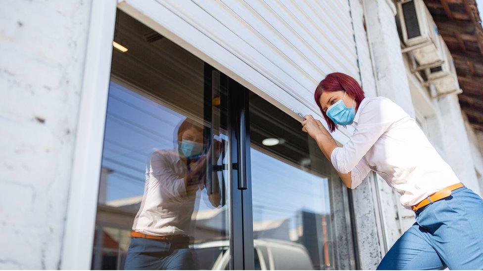 Woman shuttering a shop