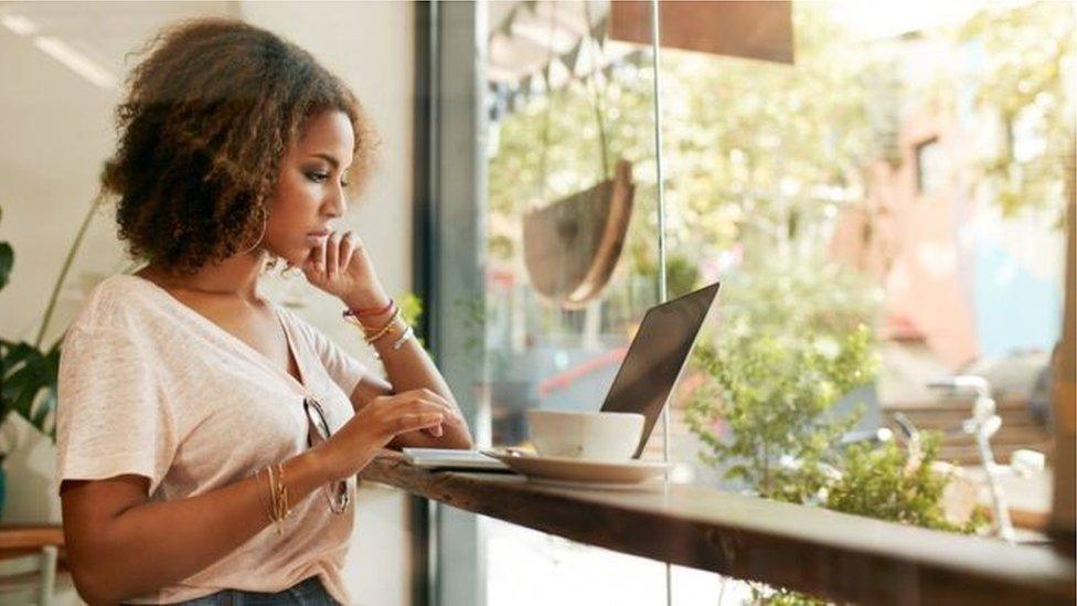 Woman at window with laptop