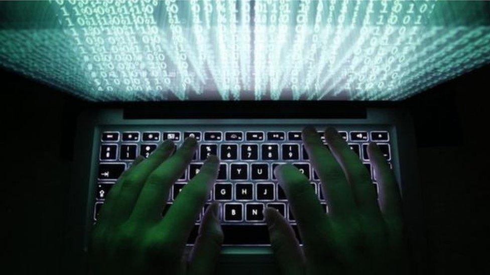 A man typing on a fluorescent keyboard