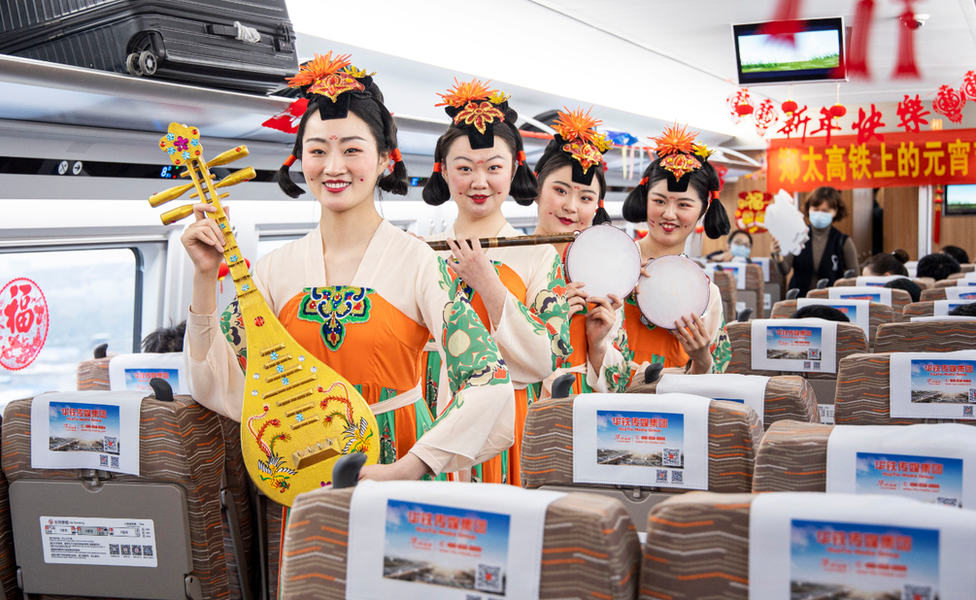 Train attendants dressed in historical costumes and holding musical instruments on board a train in Zhengzhou Photo: 26 February 2021