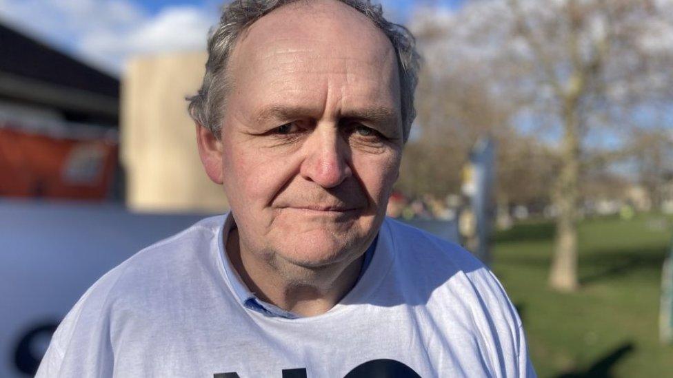 Neil Mackay looking towards camera, in a grey sweatshirt