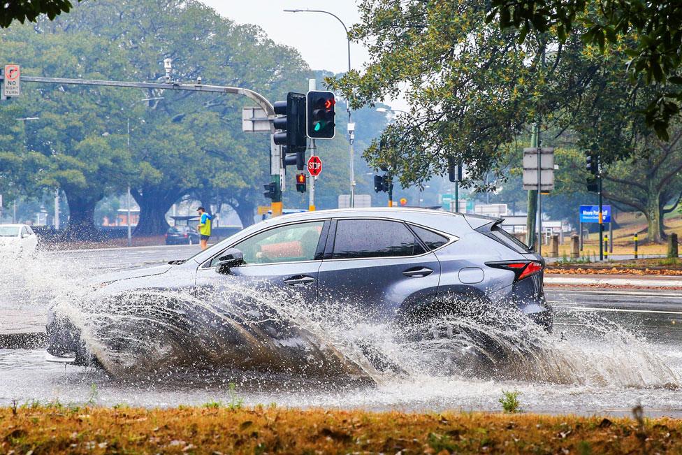 A car is seen travelling through flooded streets in Surry Hills, Sydney. 20 Jan