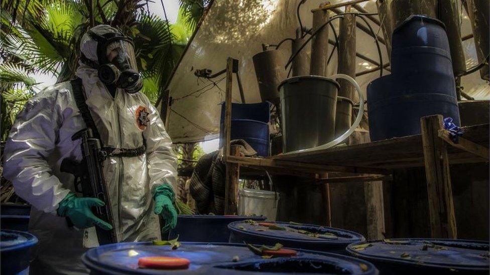 A Sinaloa state police officer works during the dismantle of one of the three clandestine laboratories producers of synthetic drug, mainly methamphetamine in El Dorado, Sinaloa state, Mexico on June 4, 2019.