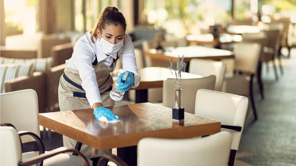 Staff member cleaning table