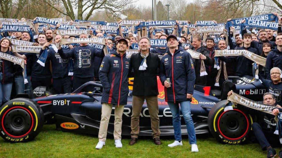 Red Bull's Sergio Perez, Christian Horner and Max Verstappen with team staff holding up scarves