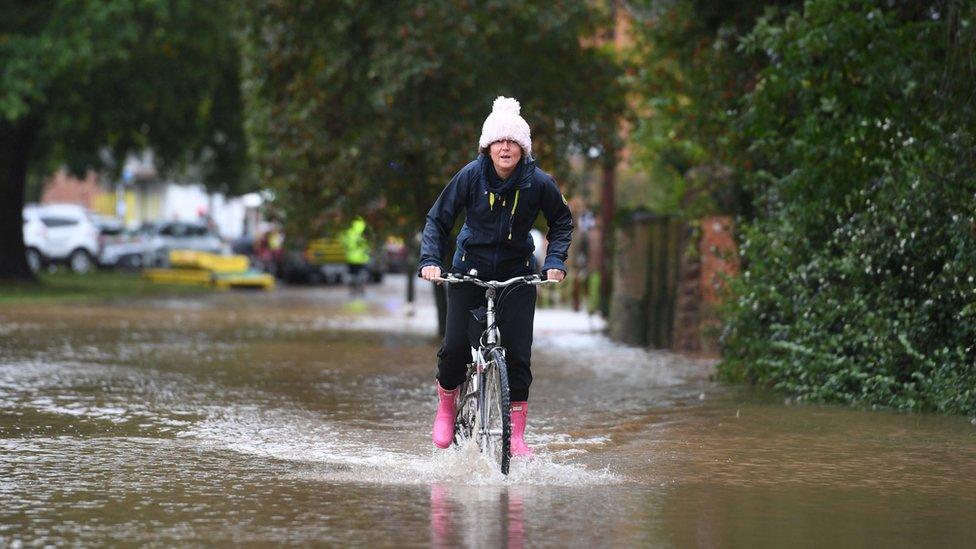 woman-cycling-through-flood-water.