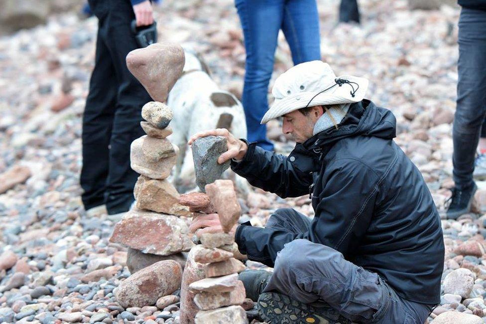 Man creating stone stack on a beach