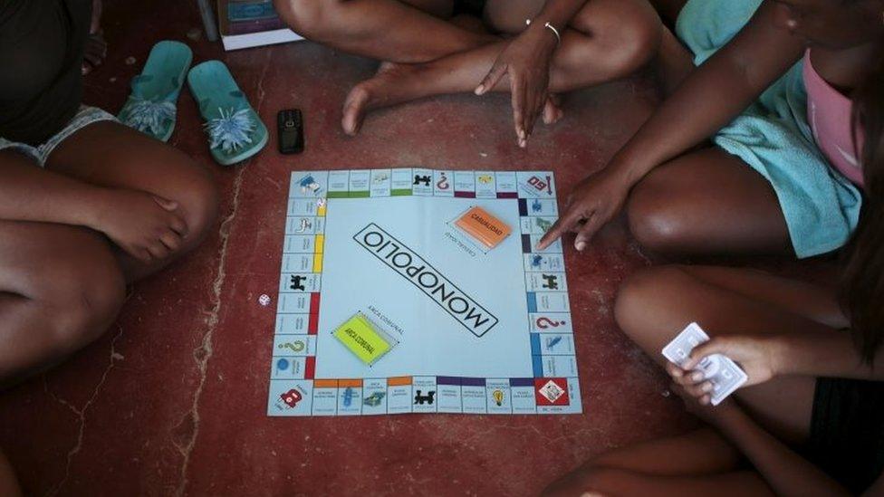 Cuban migrants play "Monopolio" board game at a temporary shelter in the town of La Cruz near the border between Costa Rica and Nicaragua on 18 November, 2015.