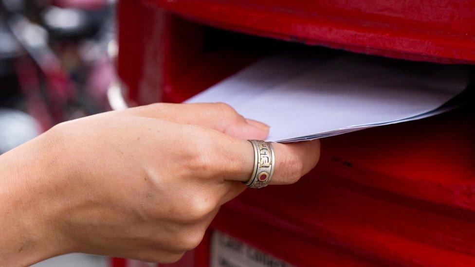 Envelopes being put into a postbox