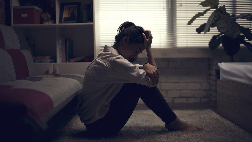 Woman sitting on the floor - file image