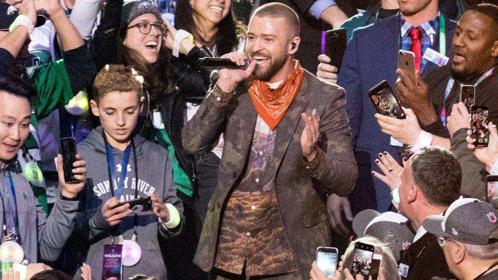 Ryan McKenna looks at his phone immediatley after posed for a selfie with Justin Timberlake in the stands