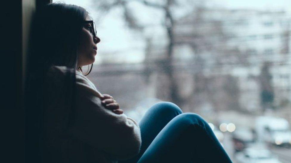 Teenager looking out of window