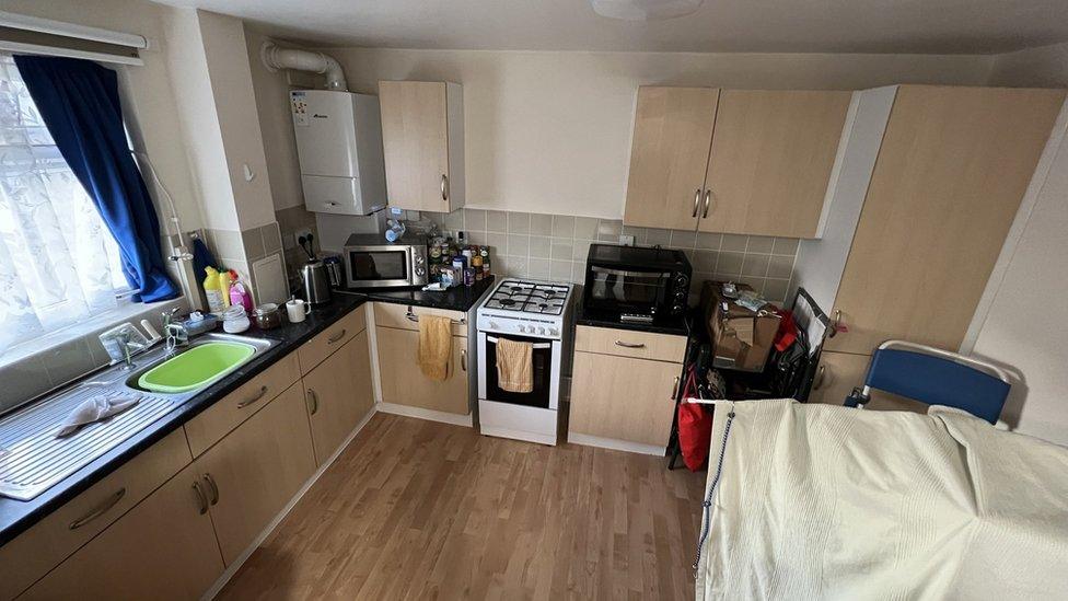 The kitchen at Carol Aldridge's flat with a commode in the corner.