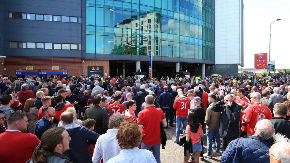 Fans wait outside Old Trafford