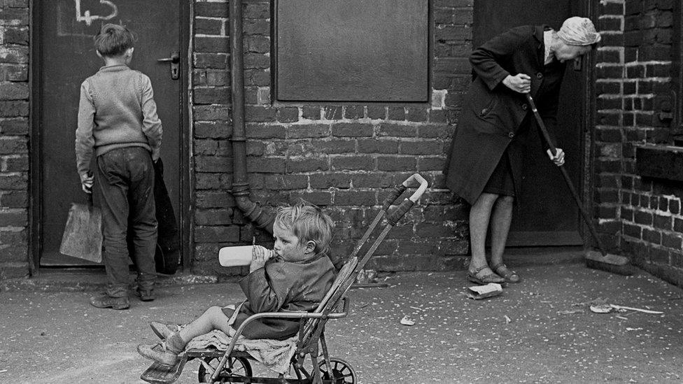 Mrs Tandy cleaning her backyard, Sheffield 1969