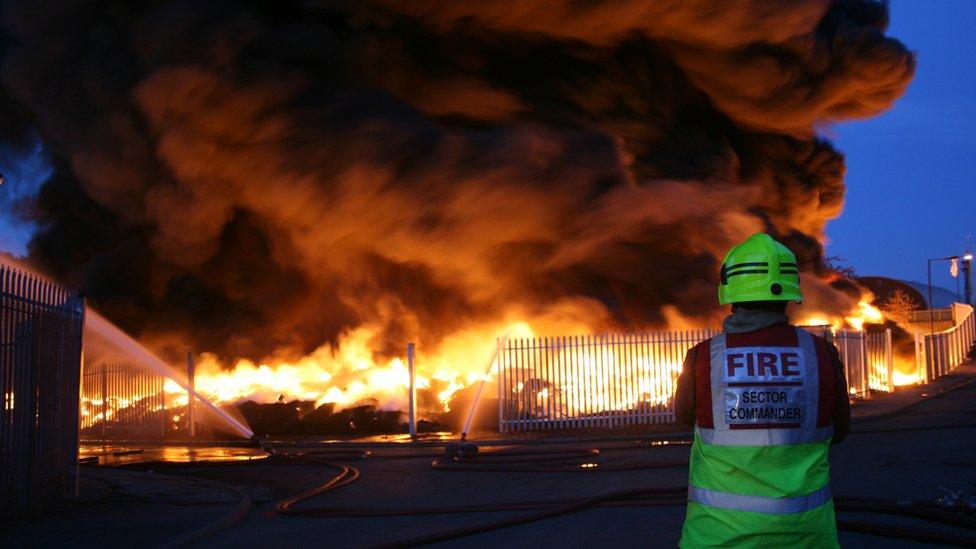 A firefighter looks at a fire