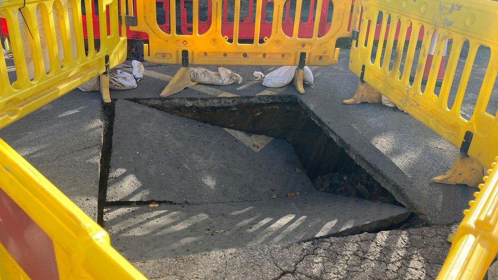 Yellow barriers around a collapsed part of the road