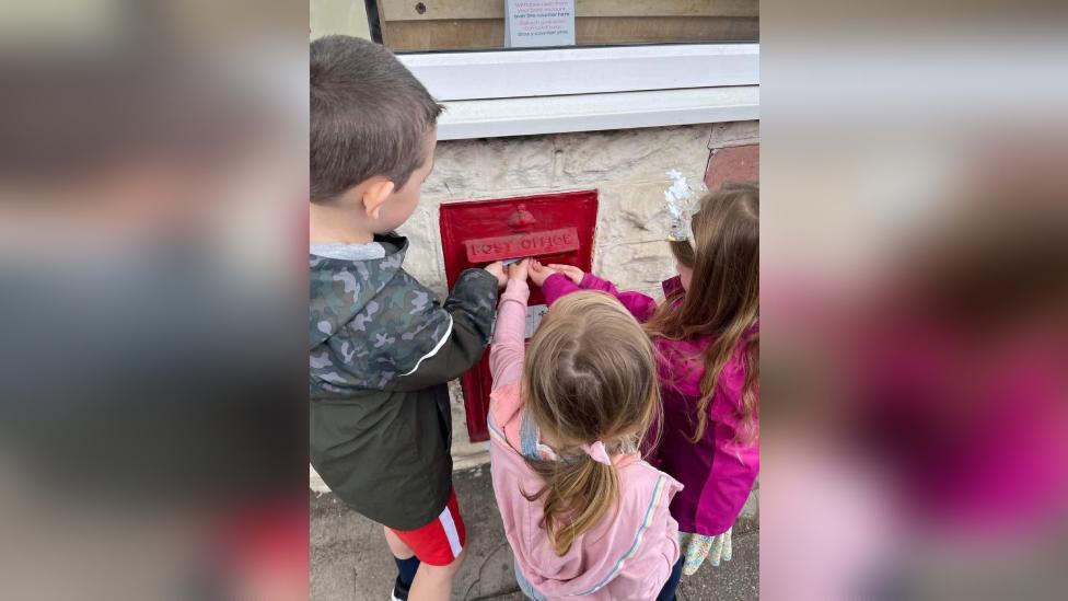 Nursery children posting their letter to the Queen