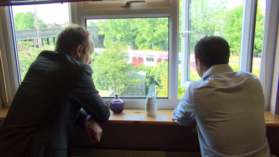 Tom Edwards and resident Ash Khan look out of his window at the nearby tracks