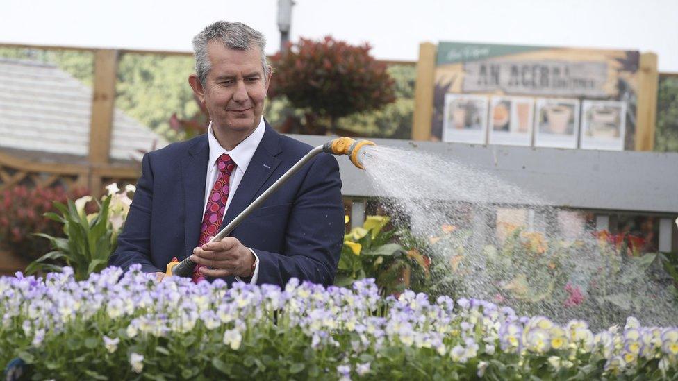 Edwin Poots watering flowers at a garden centre