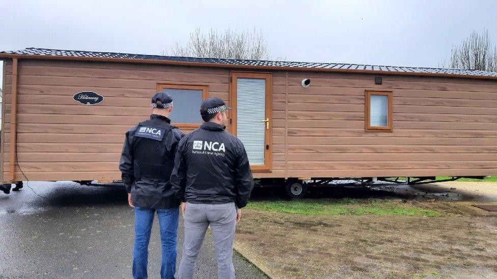 NCA officers stand outside the holiday home