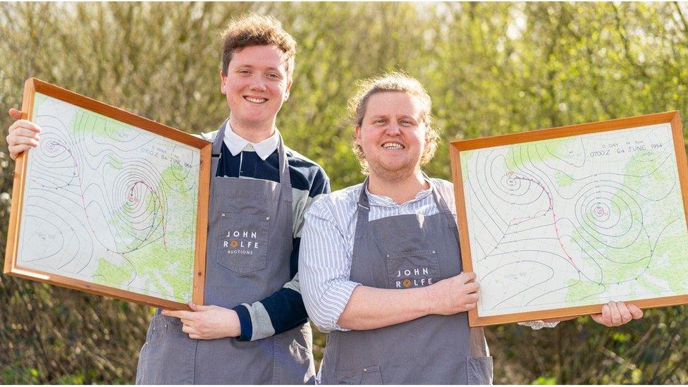 John Rolfe and his colleague holding up two of the D-Day landing maps