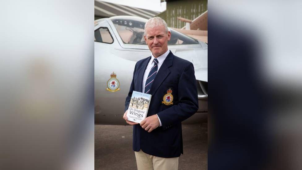 Martin Wade in his 614 uniform holding his book On Dragons Wings 