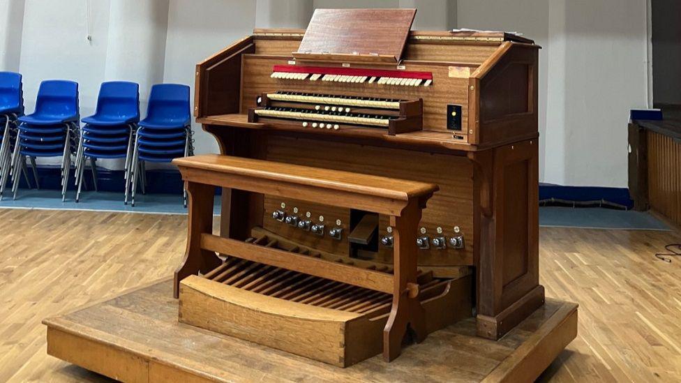 Large wooden pipe organ in the hall of a school