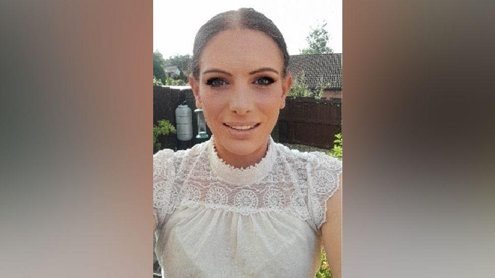Michelle Gullick has tied back hair and wears a white top