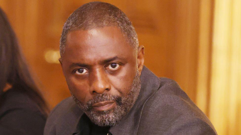 A closely cropped photo pf Idris Elba staring at the camera